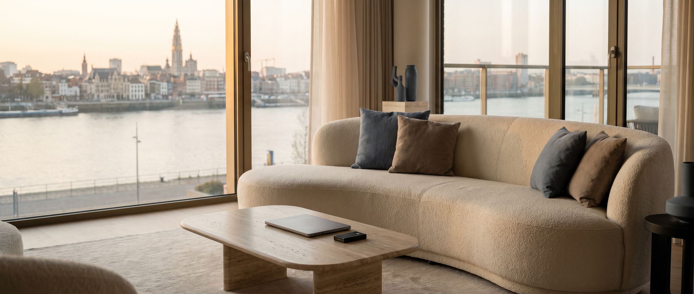Een modern appartement met zicht op de Schelde en de kathedraal, met een laptop en een hardware wallet op de salontafel